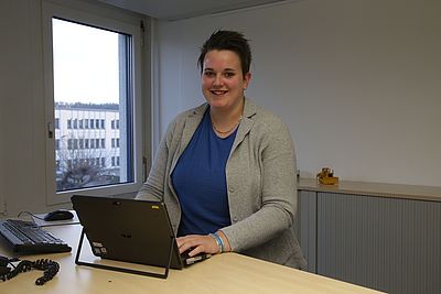 Sandrine arbeitet an ihrem Laptop im Büro