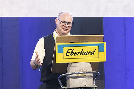 Am Nachmittag des Kundenanlass der EbiMIK Eröffnung, steht Gemeindepräsident von Oberglatt, Roger Rauper, auf eine Bühne und hält eine Ansprache