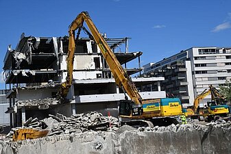 Abbruch duch Bagger mit variabel einstellbarem Ausleger.