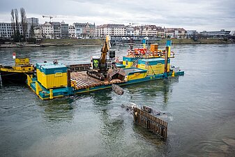 Bagger erstellt Strömungsbremse mit Steinen