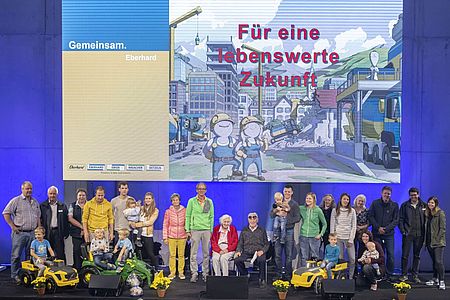 Verschiedene Generationen der Familie Eberhard stehen zusammen auf einer Bühne um am Tag der Ebianer ein Gruppenfoto zu machen