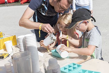 Ein Mitarbeitender der Concretum Construction Science AG zeigt Besuchern, wie man Schnellbeton verarbeitet