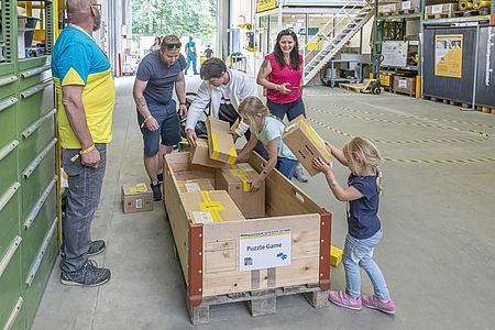 Kinder können am Tag der offnen Tür der EbiMIK Eröffnung ein Puzzle aus diversen Paketen lösen